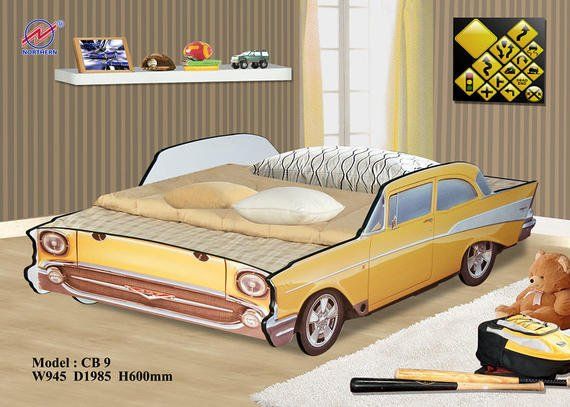 Yellow car-shaped bed in a child's room with a shelf, art, and toys.