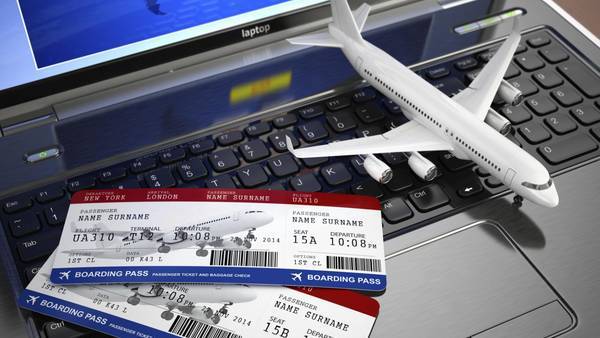 Airplane model and two boarding passes on a laptop keyboard.