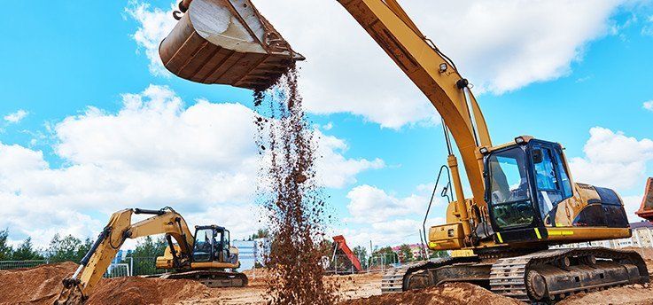 Two yellow excavators on the Sunshine Coast completing digging on worksite