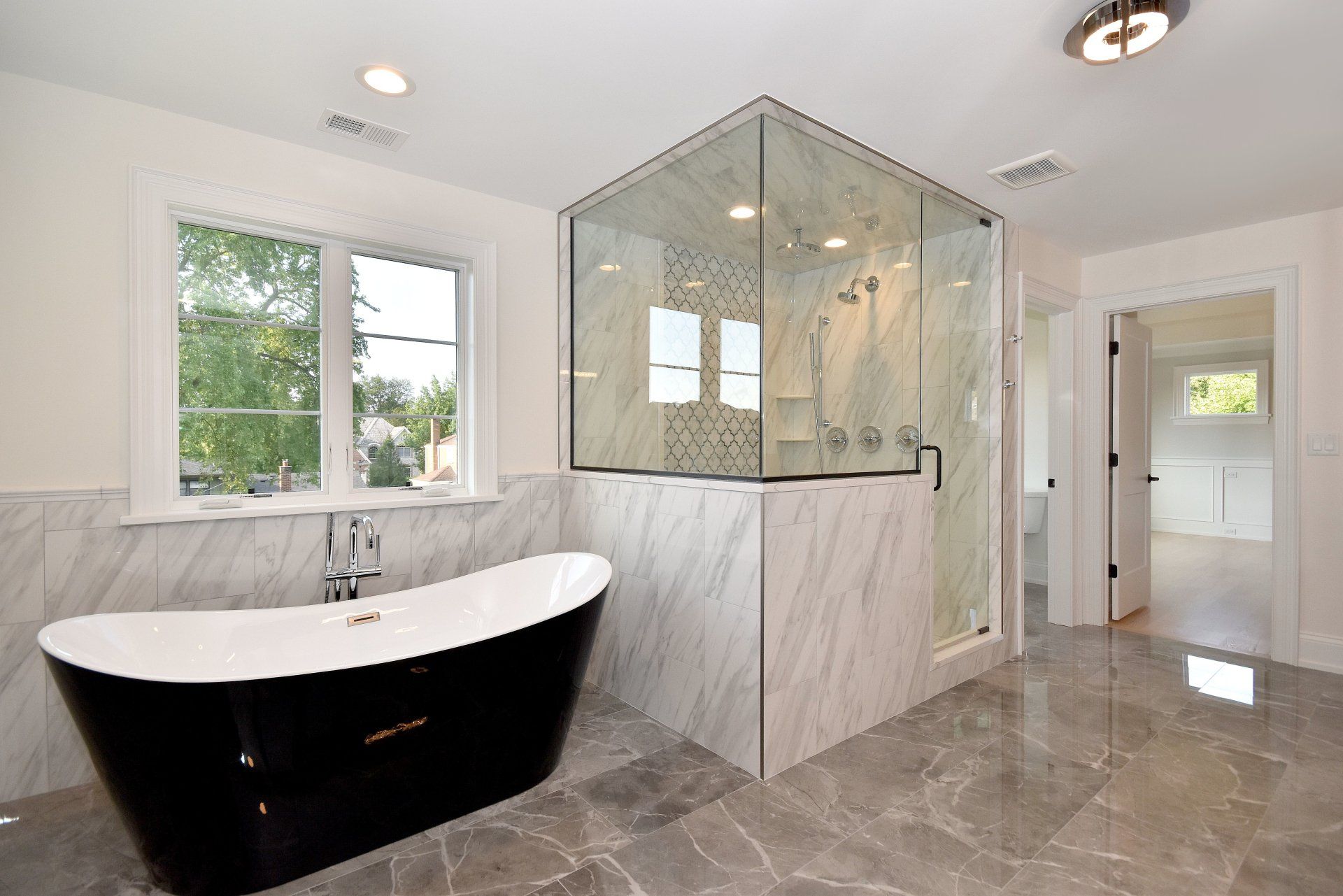 A bathroom with a black tub and a walk in shower.
