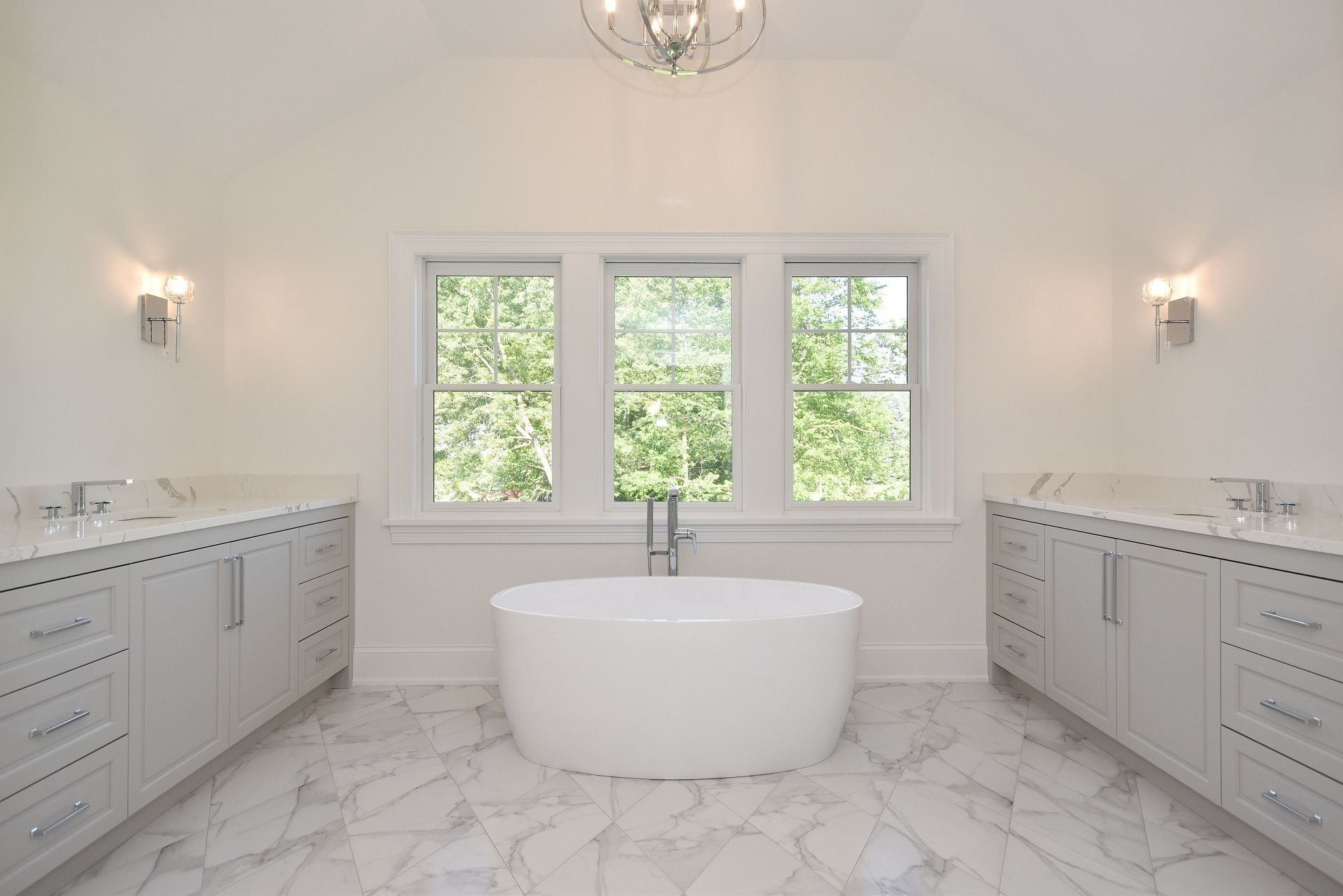 A bathroom with two sinks and a tub in the middle