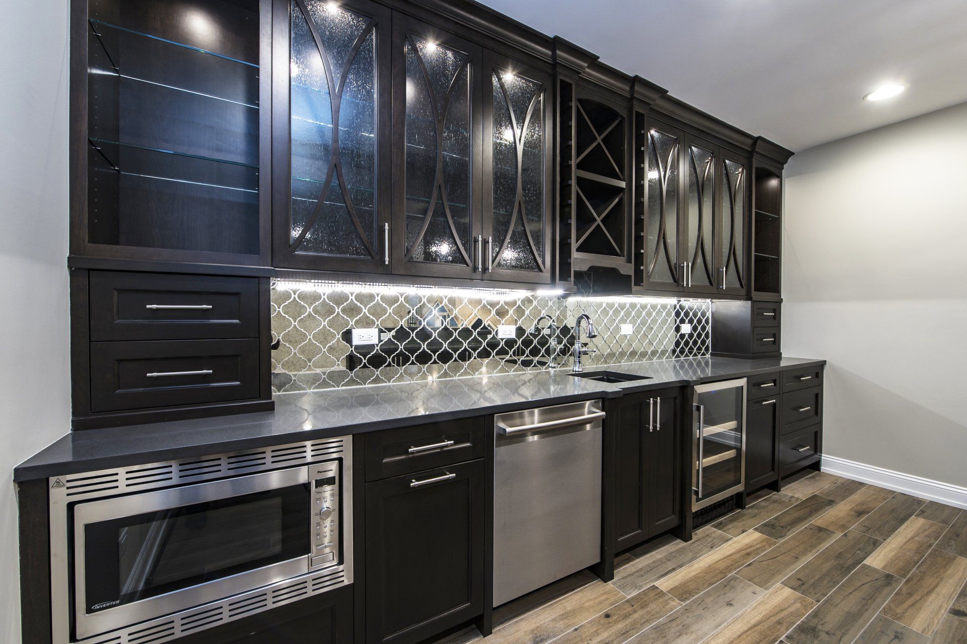 A kitchen with black cabinets and stainless steel appliances.