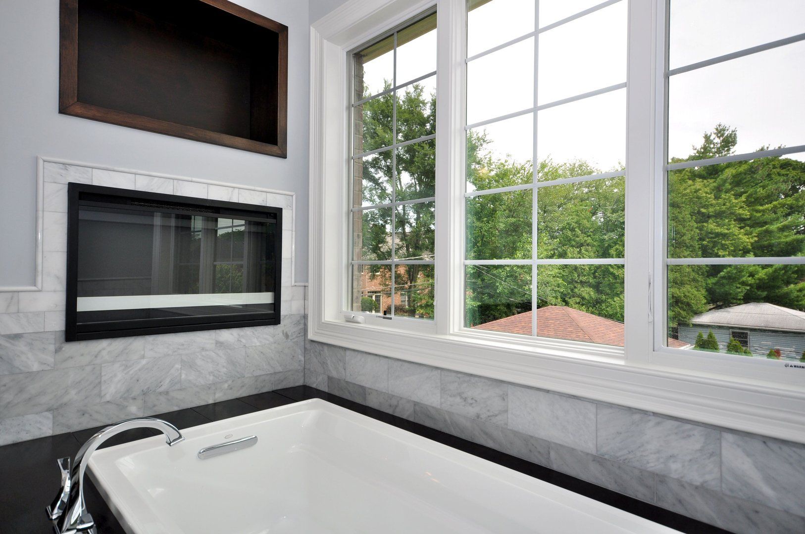 A bathroom with a bathtub and a large window