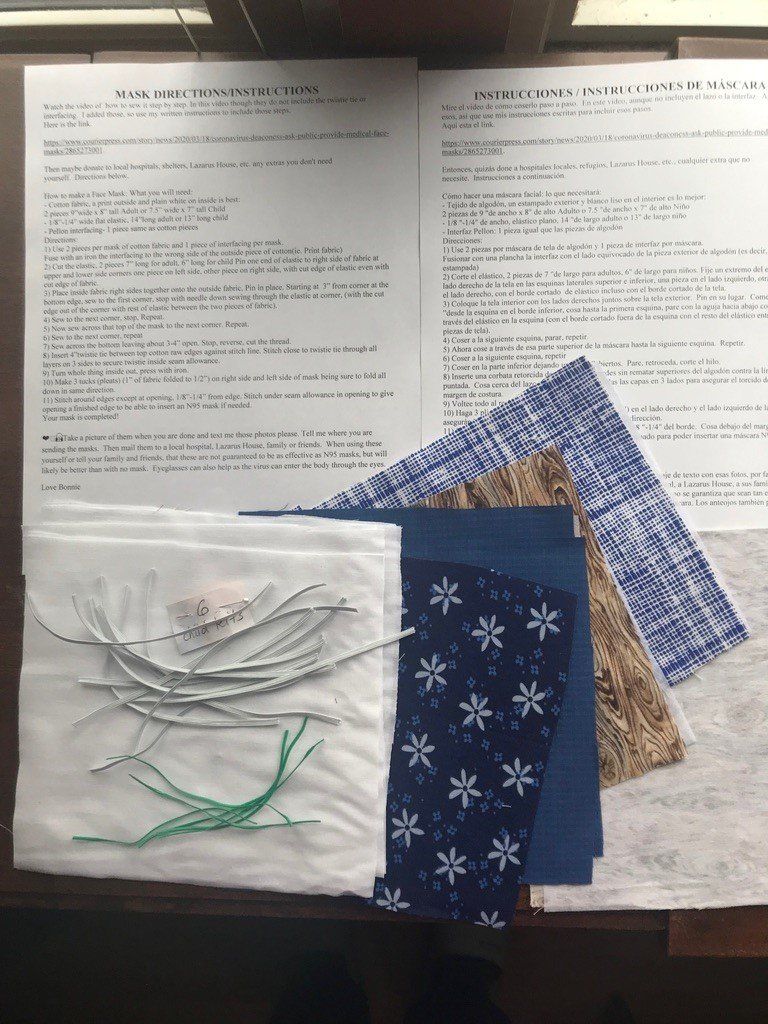 A piece of fabric with snowflakes on it sits on a table next to some papers