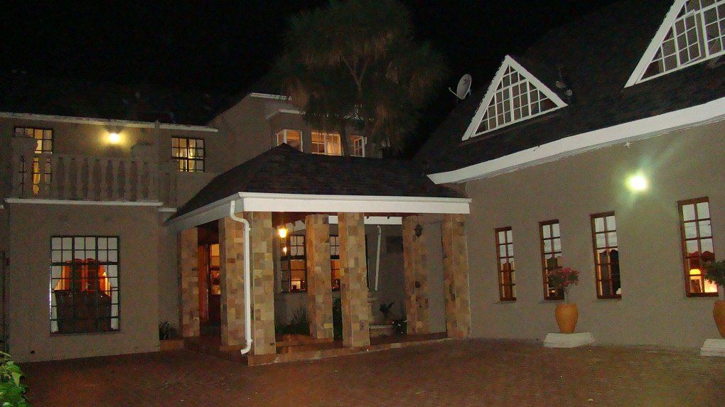 A large house with a lot of windows is lit up at night