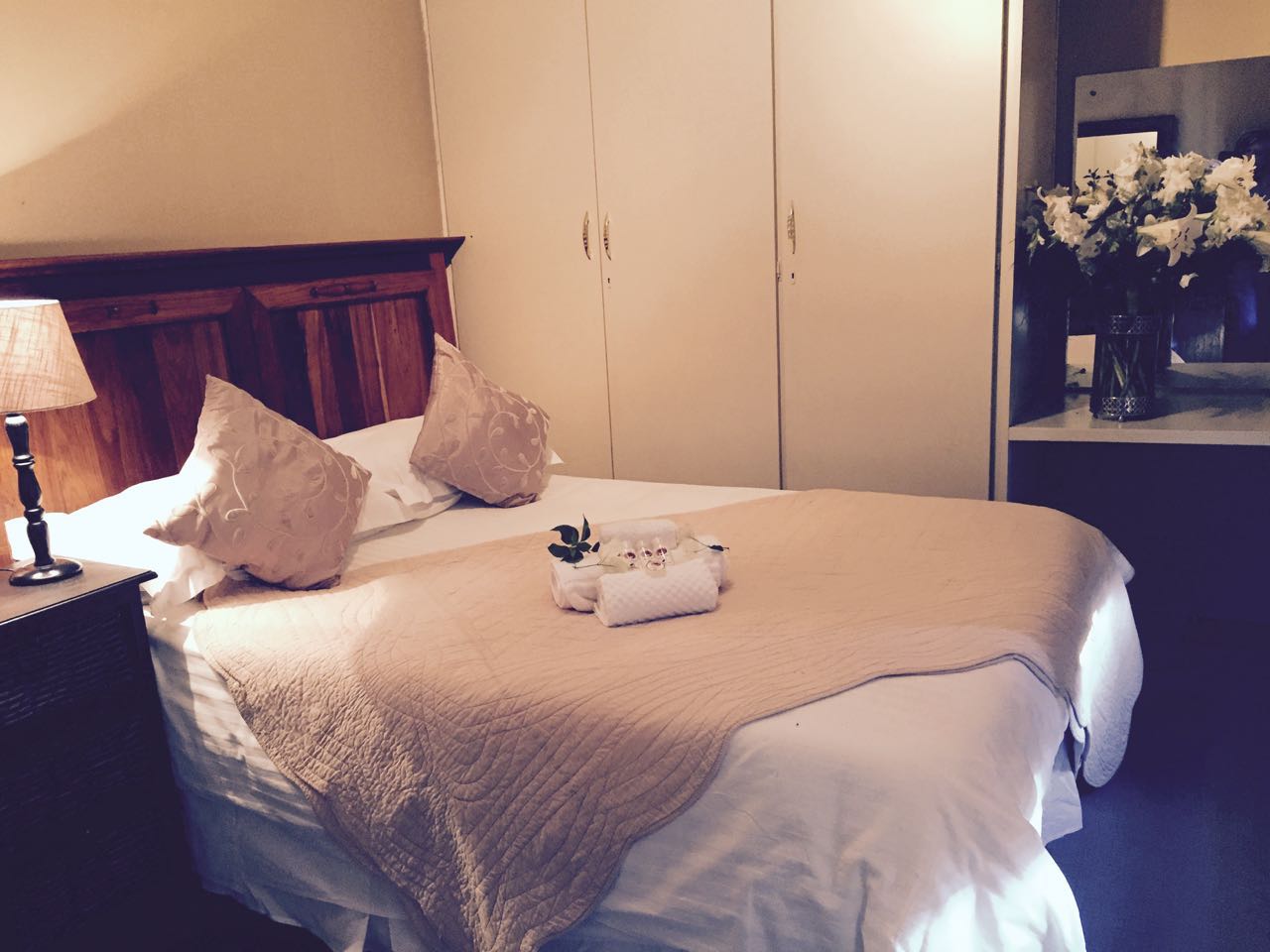 A bedroom with a large bed and a lamp