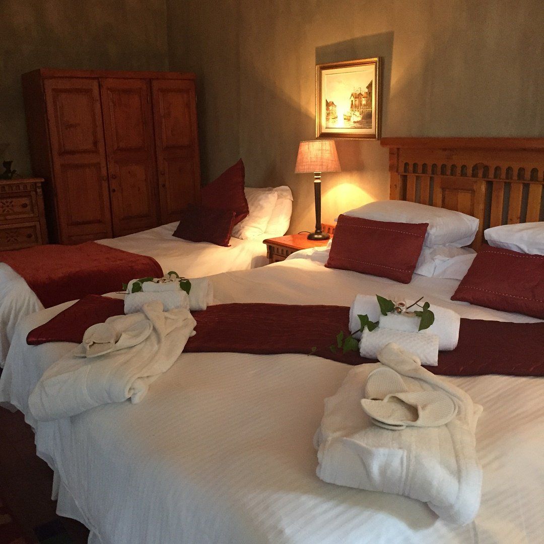 A bedroom with two beds and a lamp