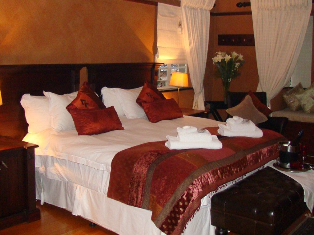 A bed in a hotel room with a red blanket