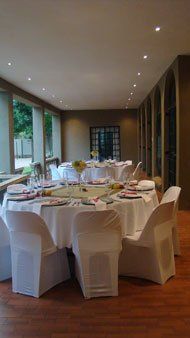 A large room with tables and chairs set up for a wedding reception.