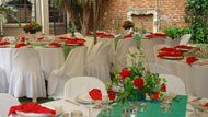 A room filled with tables and chairs decorated for a wedding reception.