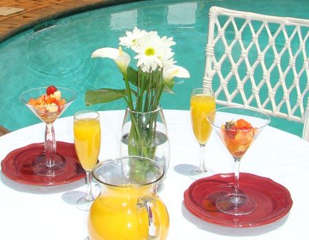 A table with a pitcher of orange juice and martini glasses
