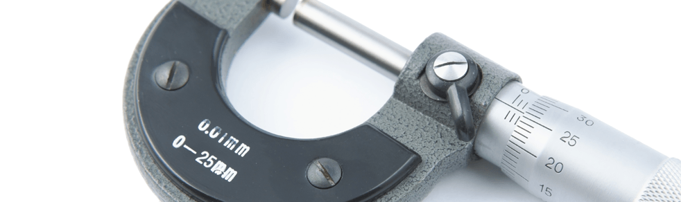 A close up of a micrometer on a white surface.