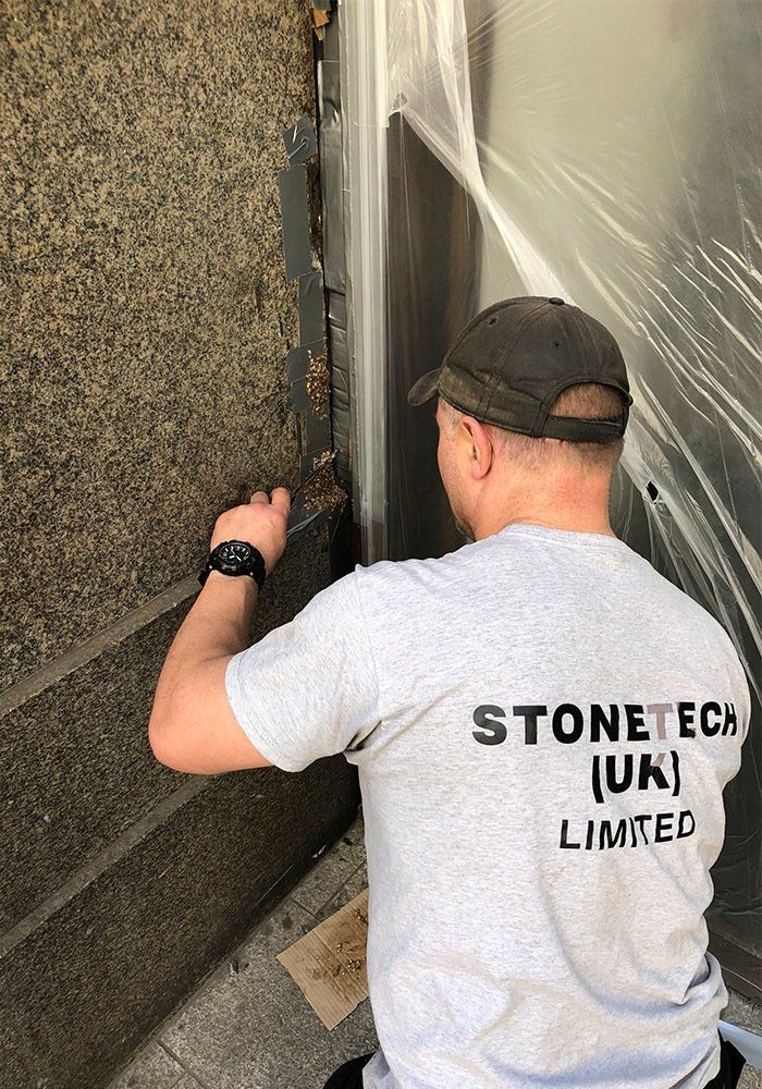 man fixing exterior stone wall