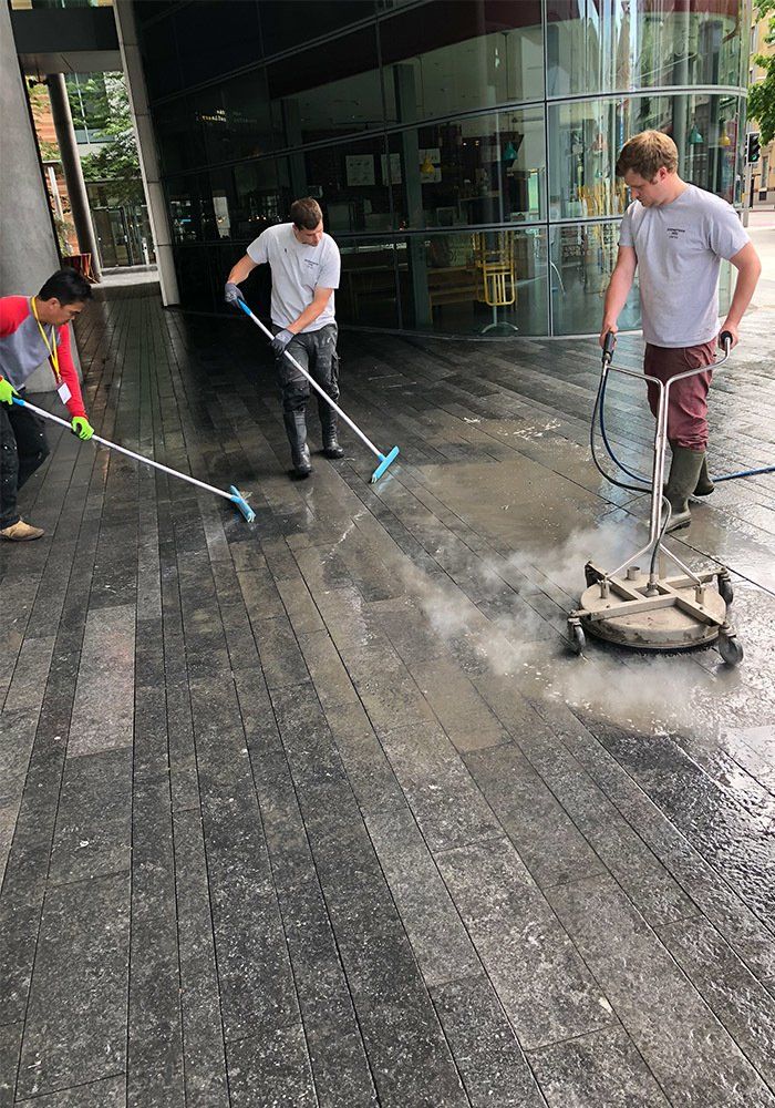 men cleaning exterior stone floor