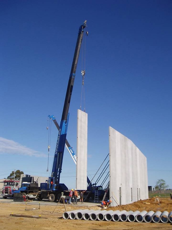 a crane putting up concrete walls