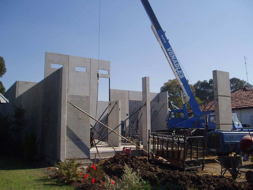 a large blue crane putting up walls