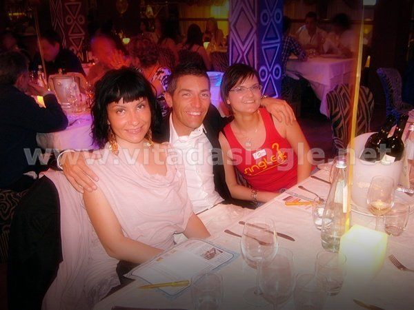 Un uomo e due donne posano per una foto seduti al tavolo del Twiga durante la cena dei single Vitadasingle.net