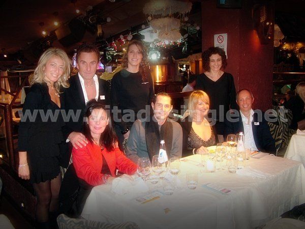 Un gruppo di persone posa per una foto al tavolo del Twiga per una cena organizzata da Vitadasingle.net