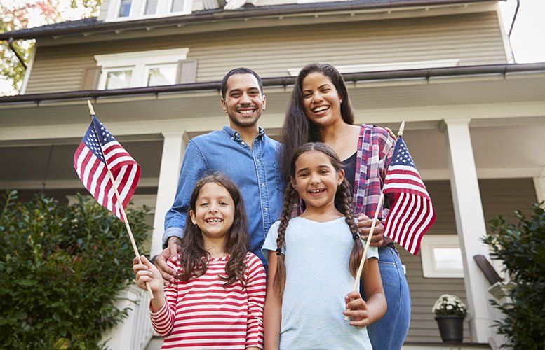 Family of four holding American flags