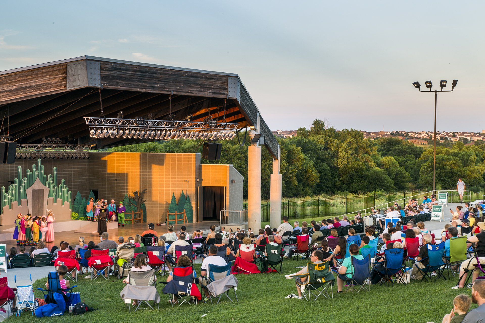 A large group of people are sitting in chairs in front of a stage.