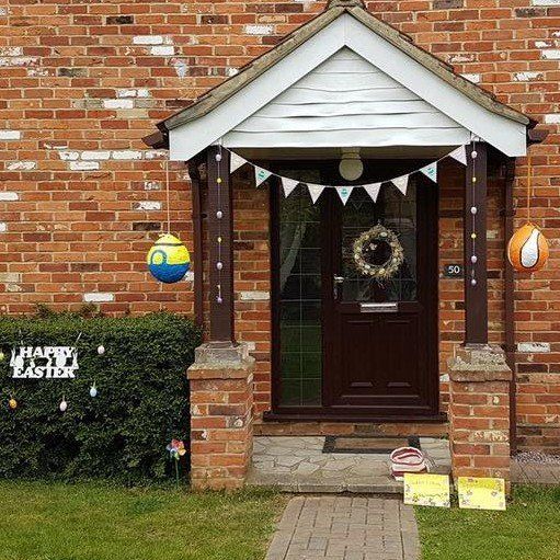 Brick home entrance decorated for Easter with eggs and bunting.