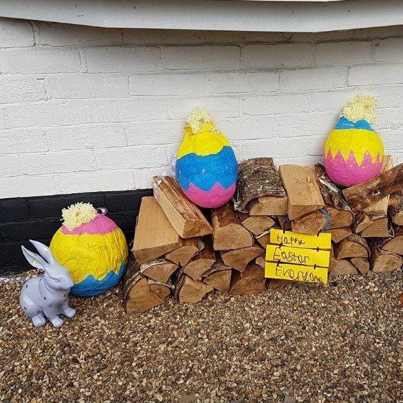 Easter display: colorful eggs, wood pile, bunny, and a