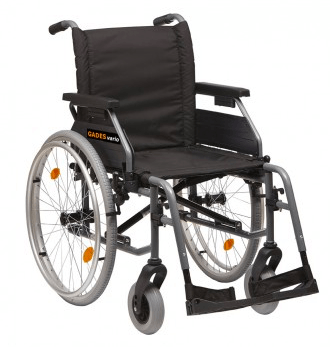 Silla de ruedas gris y negra con ruedas traseras grandes y ruedas delanteras pequeñas, orientada hacia el espectador.