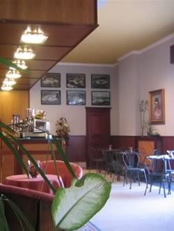 un bar con davanti dei tavoli e delle sedie