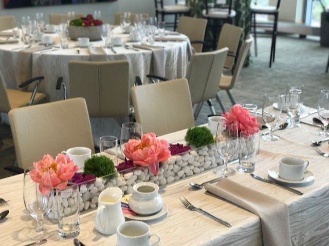 A table set for a wedding reception with flowers and glasses on it.