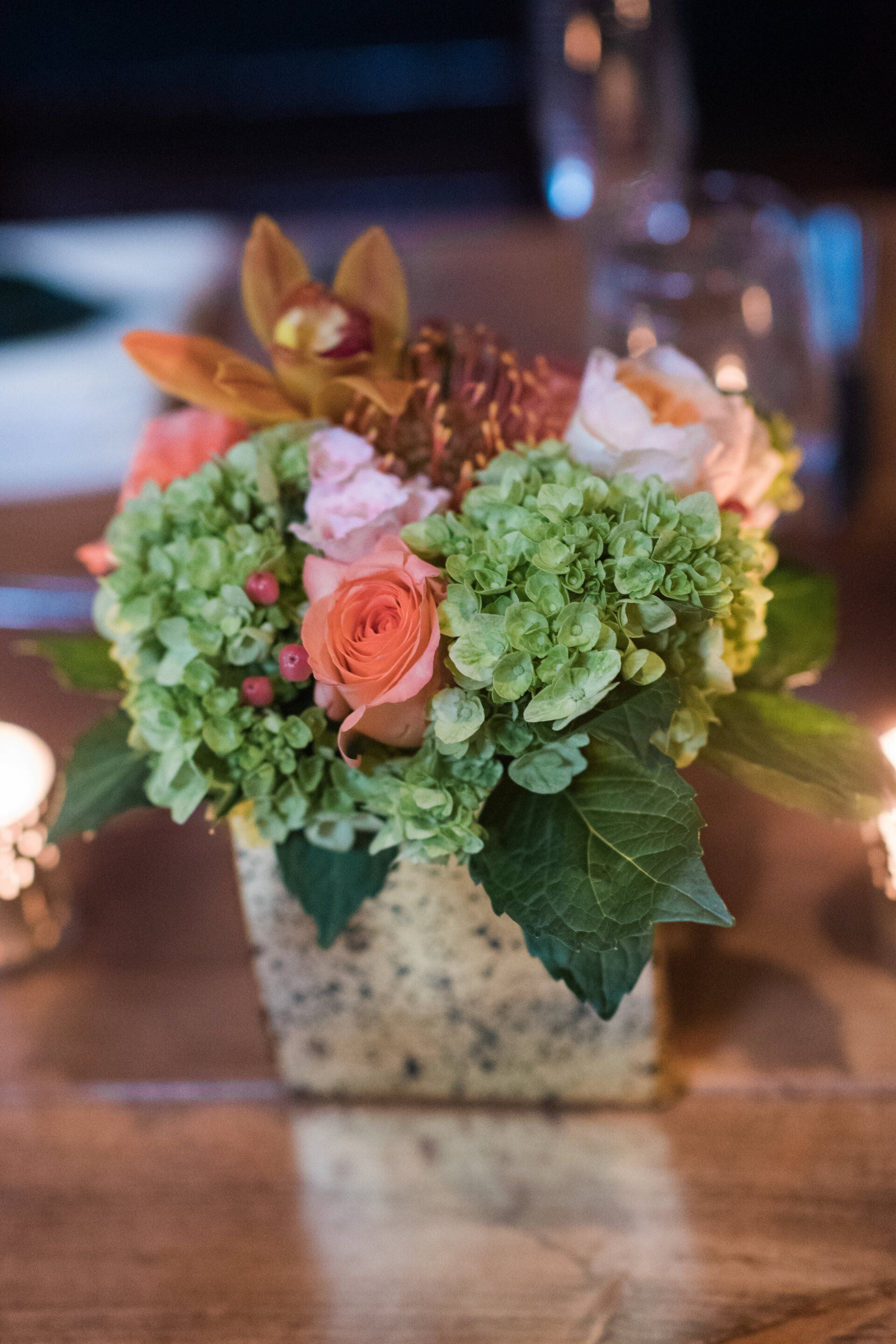 A vase filled with flowers is sitting on a wooden table.