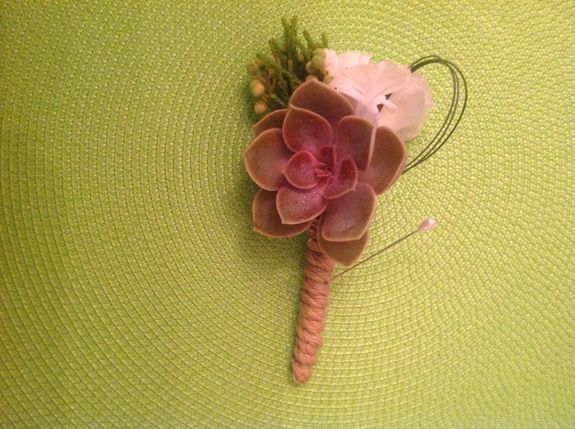 A pink flower is sitting on top of a green table.