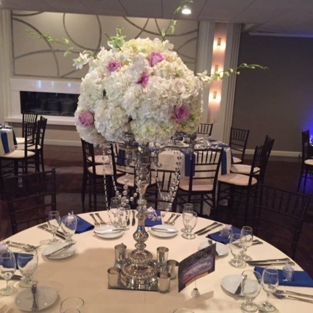 A large vase of flowers sits on a table