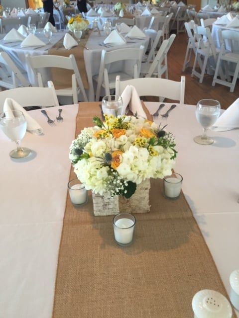 A table with a vase of flowers and candles on it
