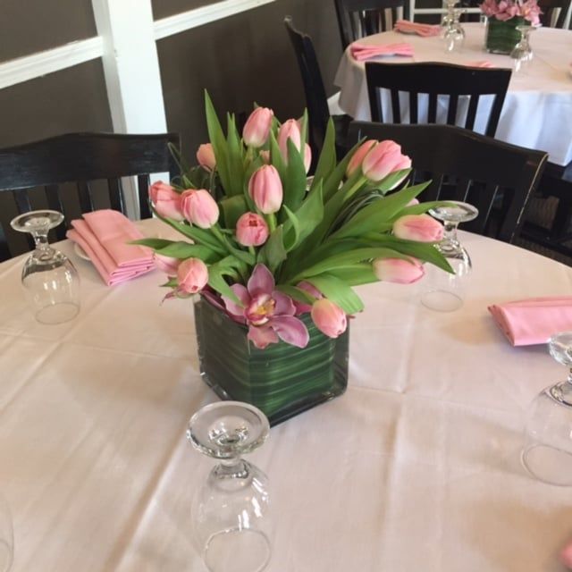 A table with a vase of pink flowers on it