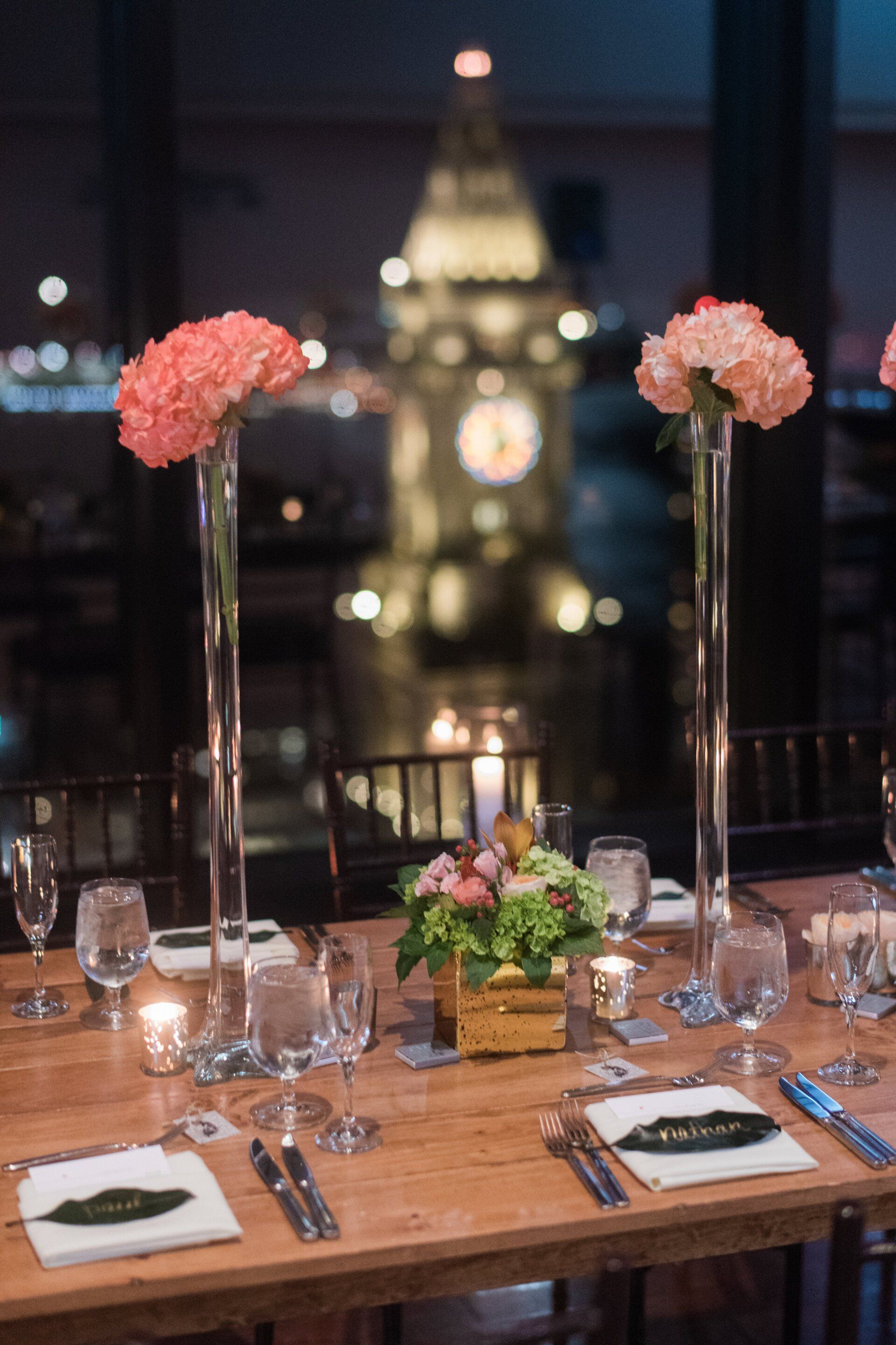 A table set for a wedding reception with a clock tower in the background