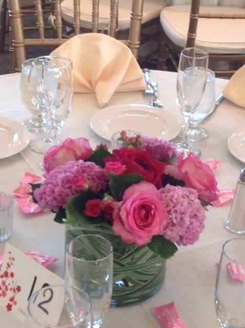 A table with a vase of pink flowers and the number 12 on it