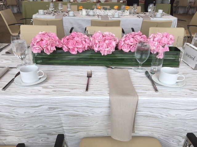 A table set for a wedding reception with pink flowers on it