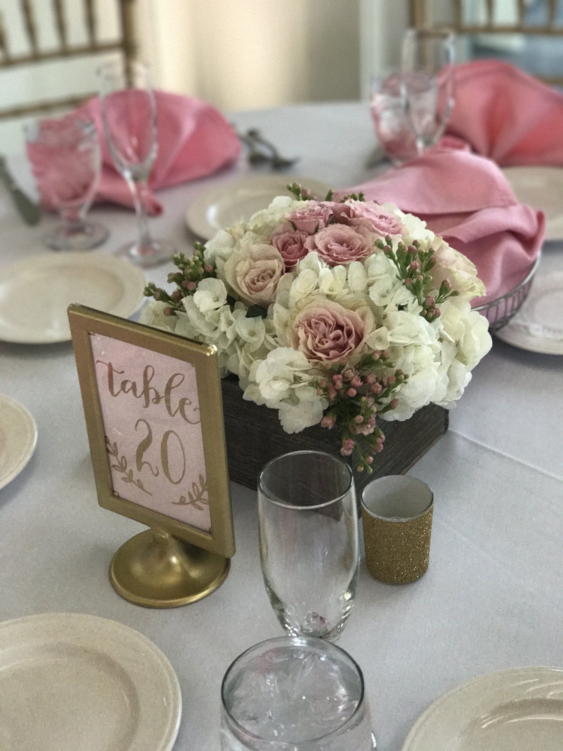 A table with plates , glasses , candles and a table number 20