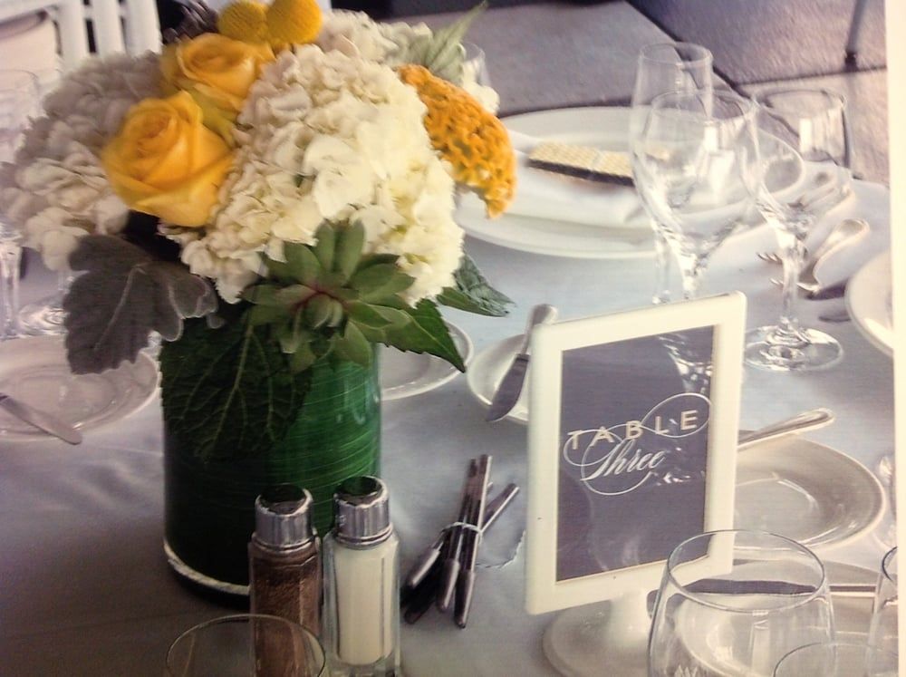 A table setting with a vase of flowers and a table number