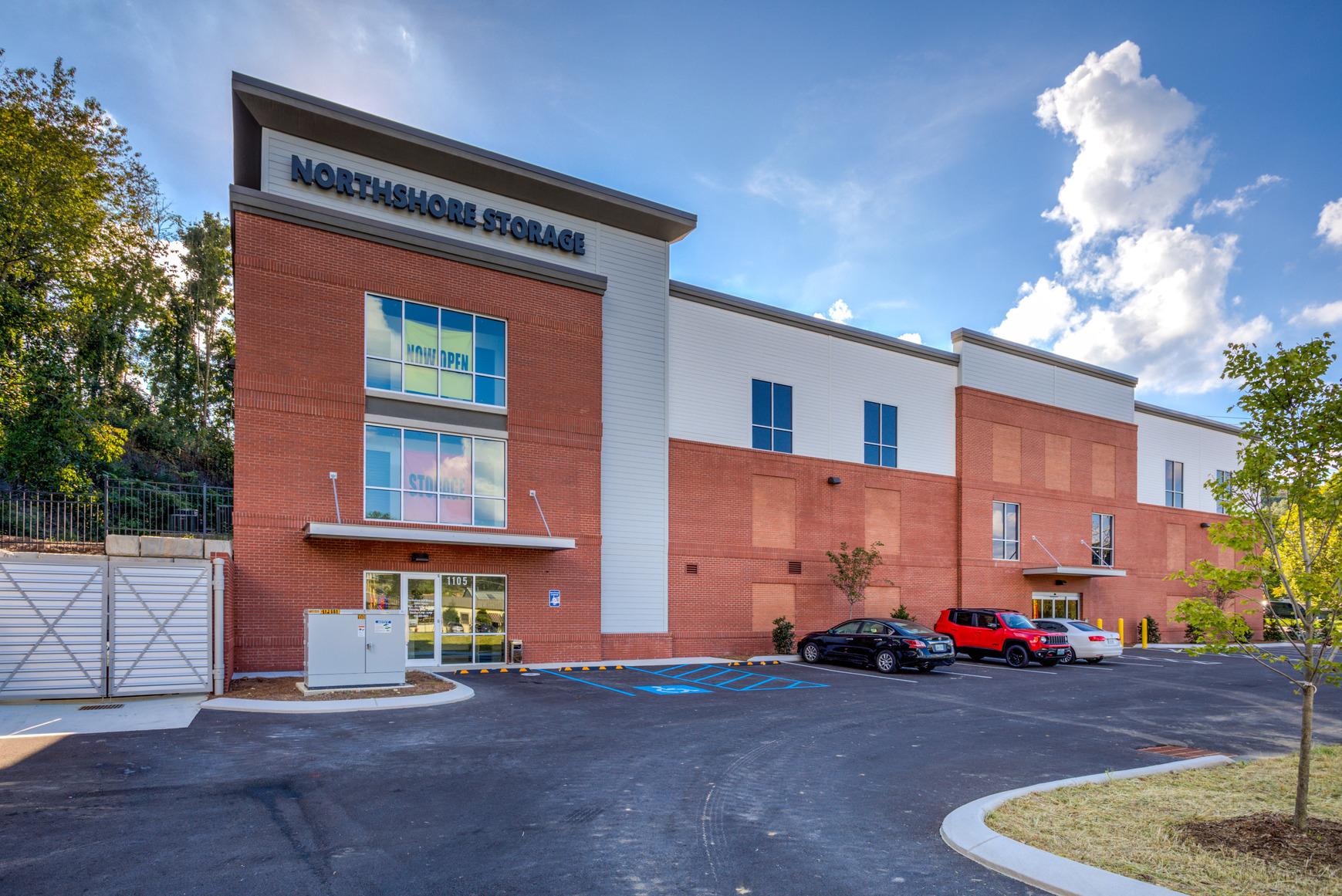 A large brick building with cars parked in front of it.