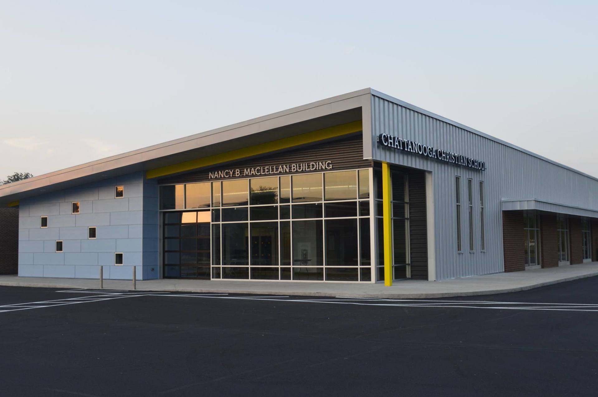 A large building with a lot of windows and a yellow pole in front of it.