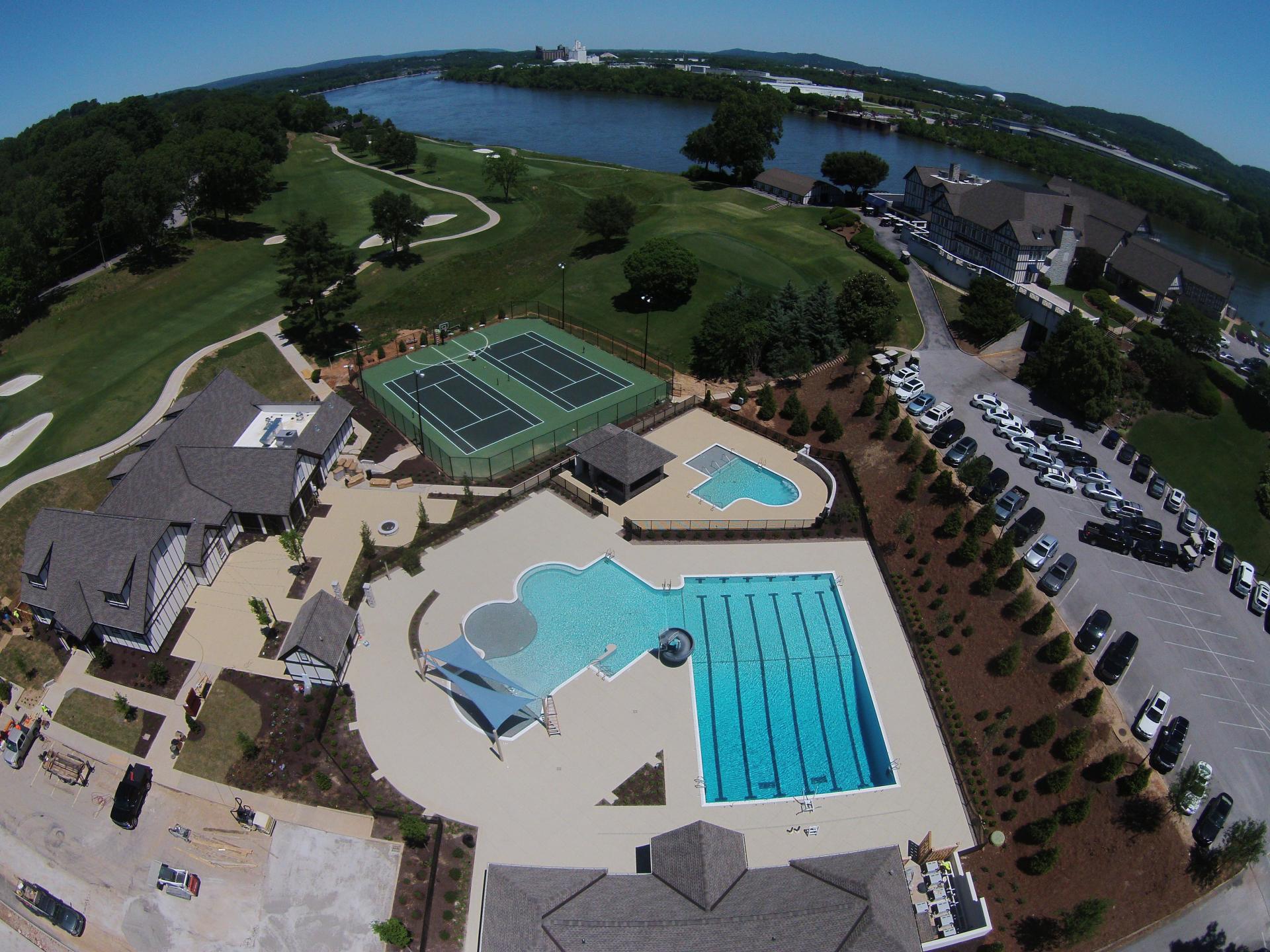 An aerial view of a tennis court and swimming pool