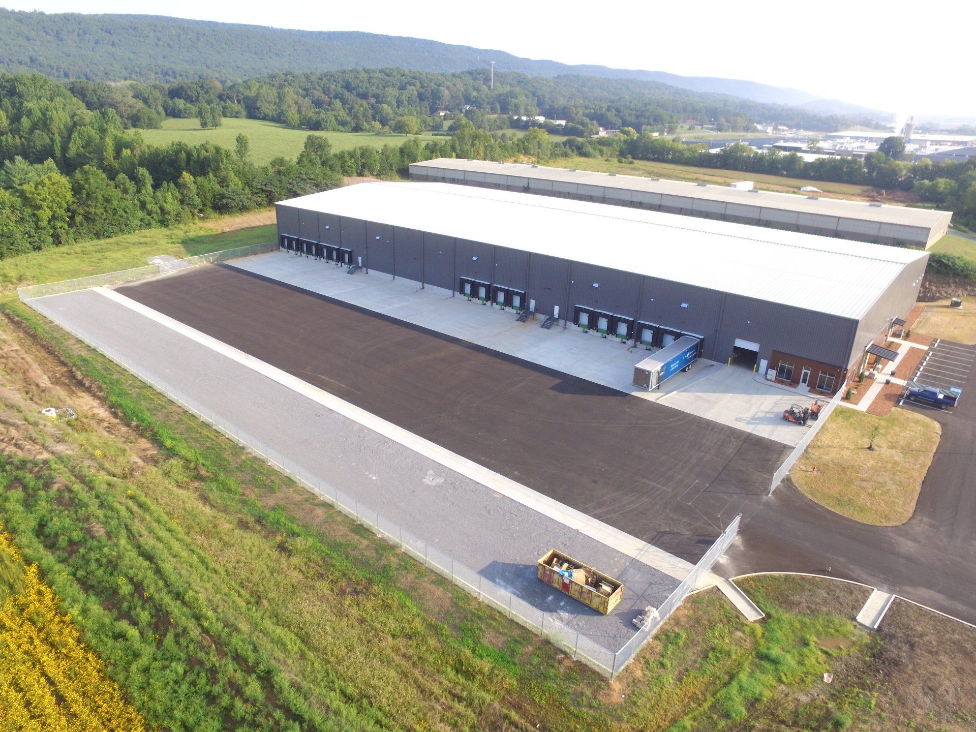 An aerial view of a large building with a lot of trucks parked in front of it.