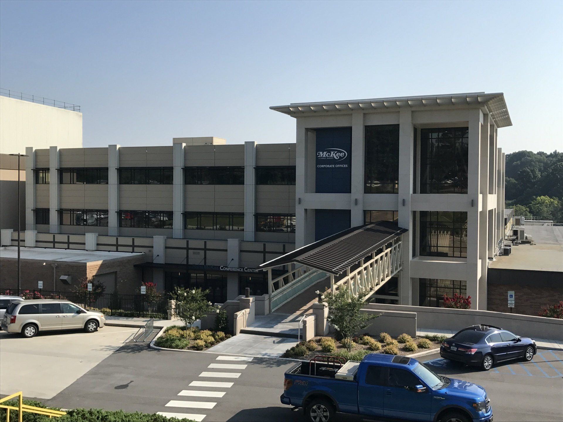 A blue truck is parked in front of a large building
