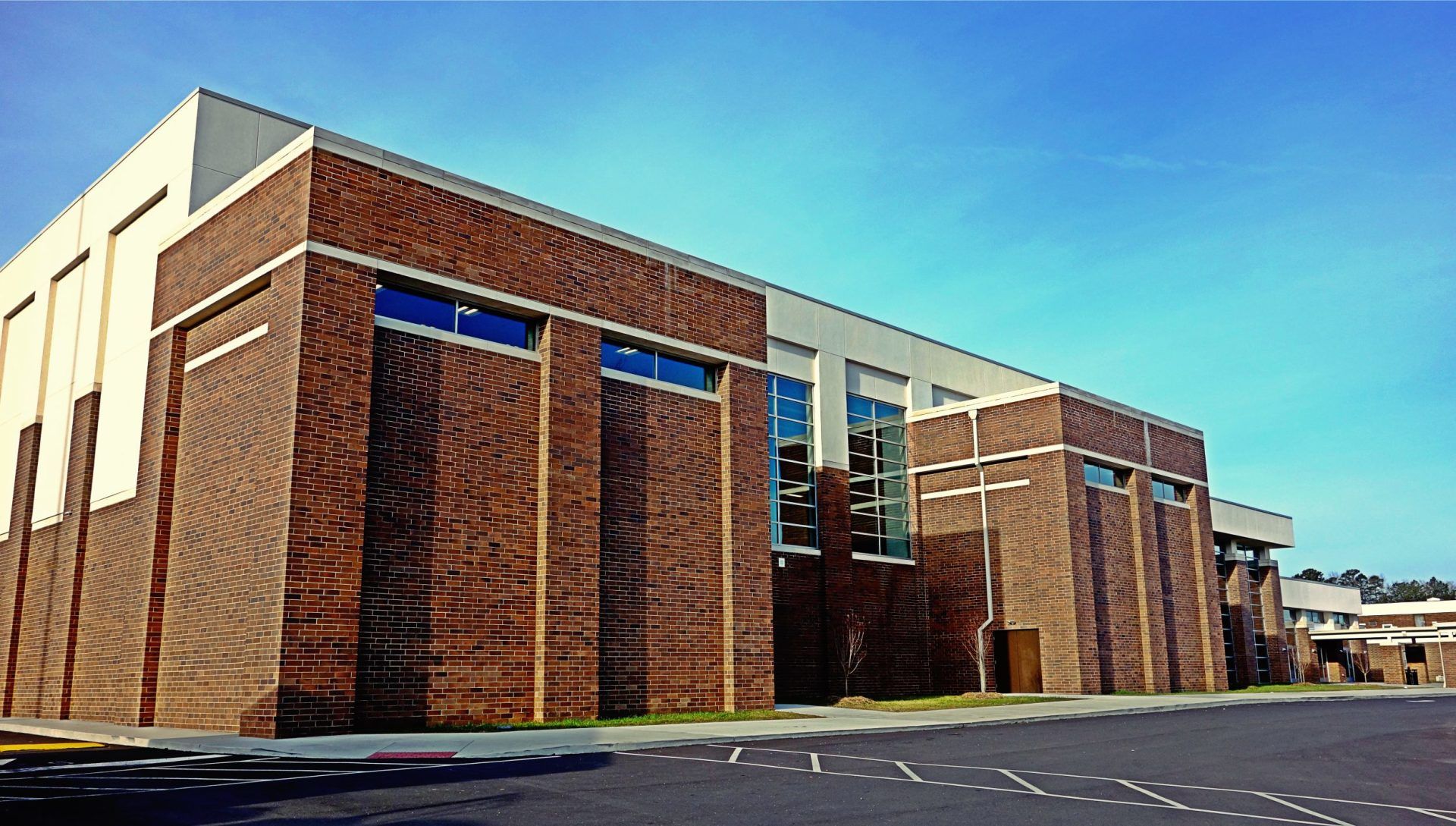 A large brick building with a lot of windows and a blue sky in the background.