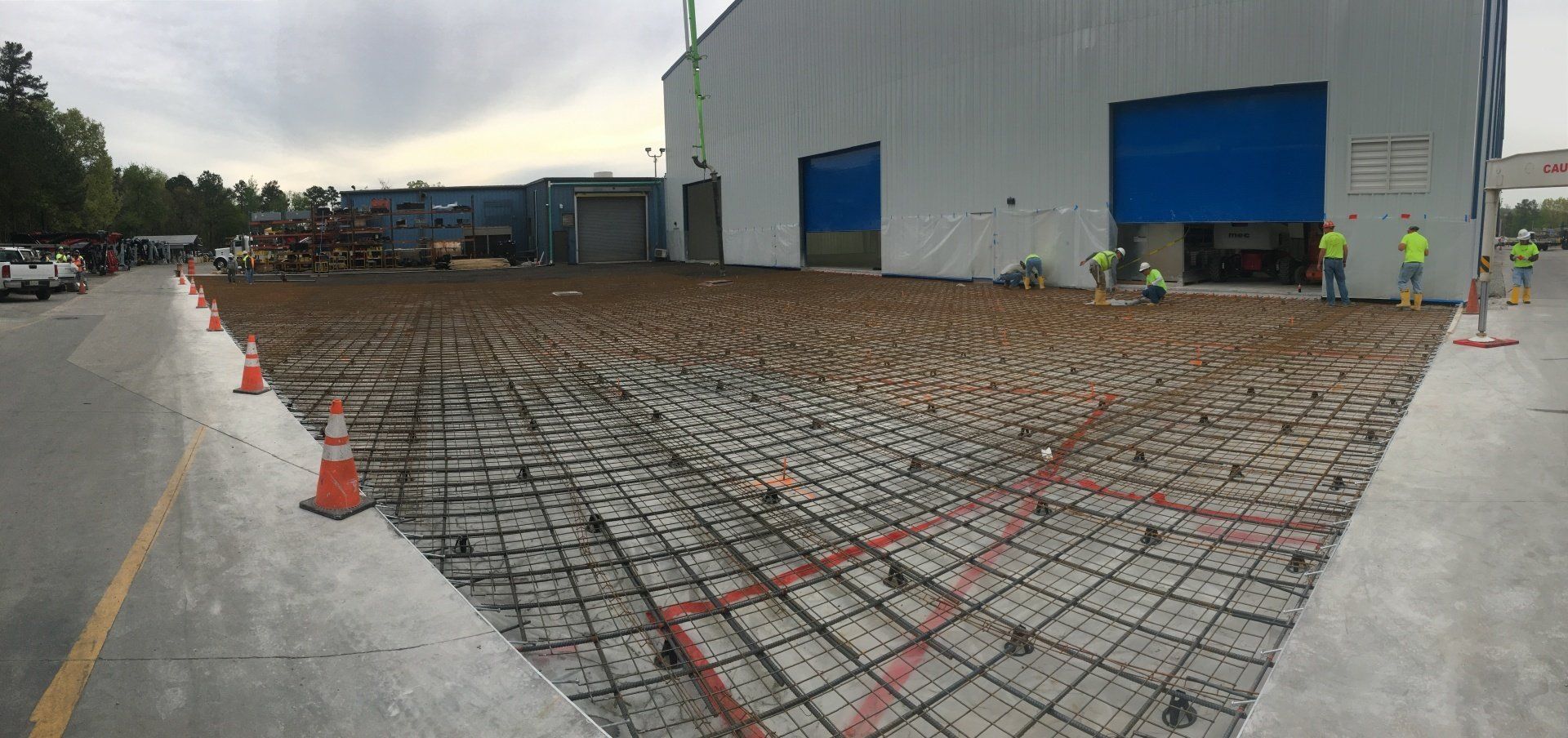 A concrete driveway is being built in front of a large building.