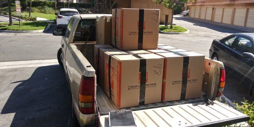 A pickup truck bed loaded with cardboard boxes.