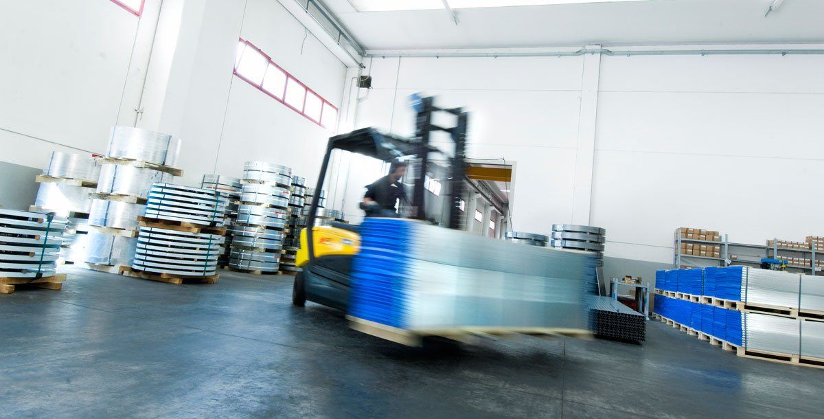 Forklift driver transporting pallet of building edge protectors.