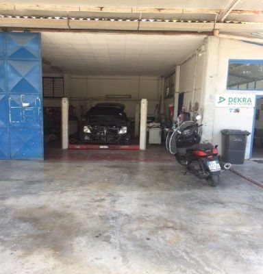 macchina in riparazione all' interno di un officina e moto parcheggiata fuori