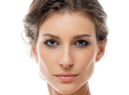 Mulher de pele clara, olhos azuis e cabelos castanhos presos para trás; olhando para a frente.